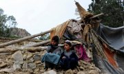 Afghanische Jungen in der Nähe ihres beschädigten Hauses, das durch ein Erdbeben im Bezirk Spera im Südwesten der Provinz Khost zerstört wurde, 22. Juni 2022. (© picture alliance / ASSOCIATED PRESS / Uncredited)