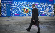 Demonstrators use a photo wall in Brussels to call for a generous EU refugee policy. (© picture-alliance/dpa)