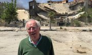 Robert Fisk in front of a bombed building in Damascus, in April 2018. (© picture-alliance/dpa)