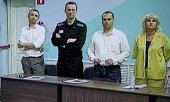Alexej Nawalny (Zweiter von links) beim Prozess mit seinen Anwälten (auf einem TV-Bildschirm). (© picture alliance/ASSOCIATED PRESS/Alexander Zemlianichenko)