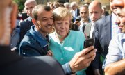 Iraqi refugee Shaker Kedida with Angela Merkel: a picture that went around the world. (© picture-alliance/dpa)