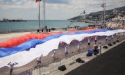 Youths unfurl a Russian flag in Yalta on "Russia Day" in 2014. (© picture-alliance/dpa)