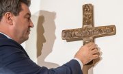 Bayerns Ministerpräsident Markus Söder hängt am 24. April 2018 ein Kreuz in der Staatskanzlei auf. (© picture-alliance/dpa)