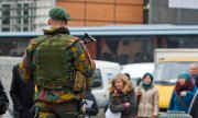 Belgian soldiers patrol in front of the seat of the European Council to protect the meeting of foreign ministers. (© picture-alliance/dpa)