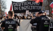 Banderole ironique sur laquelle on peut lire : 'L'Allemagne, tueuse isolée ?', brandie lors d'une manifestation commémorative le 20 février 2021, à Berlin. (© picture-alliance/dpa/Christophe Gateau)