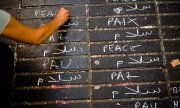 In Barcelona schreibt eine Frau in verschiedenen Sprachen "Frieden". (© picture-alliance/dpa)