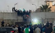 Demonstranten erklimmen die Mauer an der schwedischen Botschaft in Bagdad. (© picture alliance / ASSOCIATED PRESS / Ali Jabar)