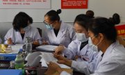 Mitarbeiterinnen der Seuchenschutzbehörde in Hohhot, China. (© picture-alliance/dpa)