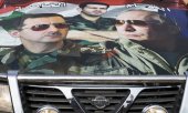 Suriye'de bir arabanın üstündeki dev Putin ve Esad fotoğrafı. (© picture-alliance/dpa)