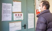 A man reads the sign at a closed government office in Milan on 24 February 2020. (© picture-alliance/dpa)