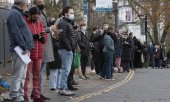 13 Aralık'ta Londra'da takviye doz bekleyenlerin aşı otobüsü önünde oluşturduğu uzun kuyruk. (© picture alliance/AA/Ray Tang)
