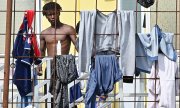 Un migrant détenu dans un centre d'accueil pour demandeurs d'asile à Turin, le 20 septembre. (© picture alliance / EPA / ALESSANDRO DI MARCO)