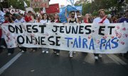 "Wir sind jung und werden nicht schweigen" steht auf einem Transparent auf einer Demonstration in Paris am 13. Oktober 2026. (© picture-alliance/MAXPPP / Julien Mattia / Le Pictorium)