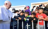 Franziskus grüßt Kinder im Erstaufnahmezentrum in Mytilene auf Lesbos am 5. Dezember. (© picture alliance/ZUMAPRESS.com/Vatican Media)