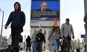 Putin's speech is broadcast on a screen in the centre of Moscow. (© picture alliance/ASSOCIATED PRESS/Dmitry Serebryakov)