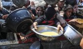 Люди в центре распределения помощи ждут раздачи еды, Газа, 23 июля 2025 года. (© picture-alliance/Anadolu/Махмуд Исса)