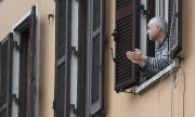 Ein Mann in Rom applaudiert vom Fenster aus Ärzten und Pflegern. (© picture-alliance/dpa)