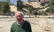 Robert Fisk, Şam'da bombalanmış bir binanın önünde (Nisan 2018). (© picture-alliance/dpa)