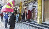 An einem Kosmetikstudio in Kabul werden am 15. August 2021 die Fotos von Frauen entfernt. (© picture alliance/Kyodo)