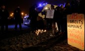 Mahnwache in Calais am 25. November. „Wie viele Tote braucht ihr noch?“ steht auf dem Plakat links. 2021 haben rund 26.000 Asylsuchende versucht, den Kanal zu überqueren. (© picture alliance/ASSOCIATED PRESS/Michel Spingler)