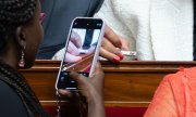 Des députés prennent en photo une punaise de lit dans un tube en verre. (© picture alliance / abaca / Lafargue Raphael/ABACA)