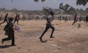 Bewohner des Gazastreifens laufen, um per Fallschirm abgeworfene Hilfsgüter zu erhalten. (© picture-alliance/dpa)