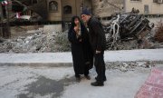 Residents of the Boroujerdi neighbourhood in Tehran stand in front of destroyed buildings following airstrikes by Israeli and American aircraft. (© picture alliance / SIPA / BERNO)