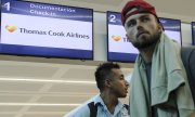 Touristen vor einem geschlossenen Thomas-Cook-Schalter am Flughafen von Cancún, Mexiko. (© picture-alliance/dpa)