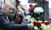 Activists with red and white flowers in front of the Belarusian embassy in Moscow. (© picture-alliance/dpa)