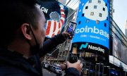 Ein Coinbase-Mitarbeiter feiert den Start am 14. April am Times Square in New York. (© picture-alliance/Richard Drew)