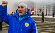 В ходе подавления протестов были убиты многие демонстранты. На заднем фоне - горящее здание городской администрации Алма-Аты. (© picture-alliance/dpa/ТАСС/Ерлан Джумаев)