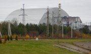 A view of the sarcophagus covering Reactor Blocks 4 and 3 at Chernobyl. The steel and concrete shield was built after the disaster and reinforced with a second layer between 2010 and 2016. (© picture alliance / DeFodi Images Patrick Ahlborn)