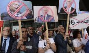 George Soros, Donald Tusk et Frans Timmermans sur des pancartes brandies par les partisans du gouvernement, le 26 juillet 2017, à Varsovie. (© picture-alliance/dpa)