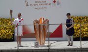 Канкуро Накамура - спортсмен, доставивший факел с олимпийским огнём на стадион в Токио, с губернатором Юрико Коике. (© picture-alliance/Кантаро Комийя)