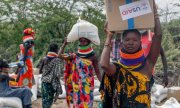 Women carrying aid supplies in northern Kenya in July. (© picture alliance/ASSOCIATED PRESS/Desmond Tiro)