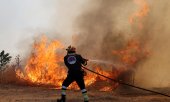 A Greek firefighter dousing one of countless fires.