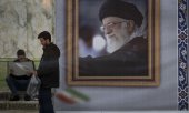 Ein Mann steht in Teheran neben einem Porträt des Obersten Führers des Iran, Ajatollah Ali Chamenei. Dieser hatte die USA vor einem "regionalen Krieg" gewarnt. (© picture alliance / NurPhoto / Morteza Nikoubazl)