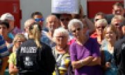 Right-wing demonstrators protest against Merkel in front of the shelter. Already at the weekend, applicants for asylum had been threatened there. (© picture-alliance/dpa)