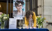 A guest signing a book of condolences after a memorial service in Belfast. (© picture-alliance/dpa)
