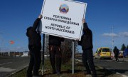 Workers putting up a new sign in Gevgelija on the border between Greece and North Macedonia with the countries' names on 13 February 2019. (© picture-alliance/dpa)