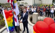 The CEO of the Bank of America raises the LGBT flag for Pride Month 2019. (© picture-alliance/Paul Bersebach)