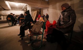 People in Kyiv shelter from missile attacks in the basement of a school on February 24. (© picture alliance/EPA/SERGEY DOLZHENKO)