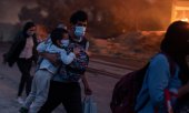 İnsanlar kurtarabildikleri bir avuç eşyalarıyla yanan Moria Kampı'ndan kaçarken. (© picture-alliance/dpa)