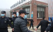 Des policiers encadrent la délégation de l'OMS à Wuhan, le 3 février 2021. (© picture-alliance/Koki Kataoka)