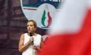 Parti lideri Meloni, 20 Temmuz 2022'de Roma'da alevli logonun önünde. (© picture alliance/ZUMAPRESS.comCecilia Fabiano)