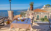 Table with a view of the rooftops of Taormina on the Italian island of Sicily. (© picture-alliance/dpa)